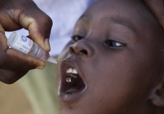 A child in the village of Azuretti, Cote d'Ivoire, receives polio vaccine during a National Immunization Day, 27 April 2013. Find the story in "The Rotarian," October 2013, pages 45-51.